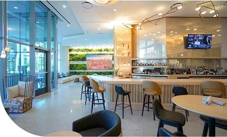 A curved bar with tables and chairs spread around it