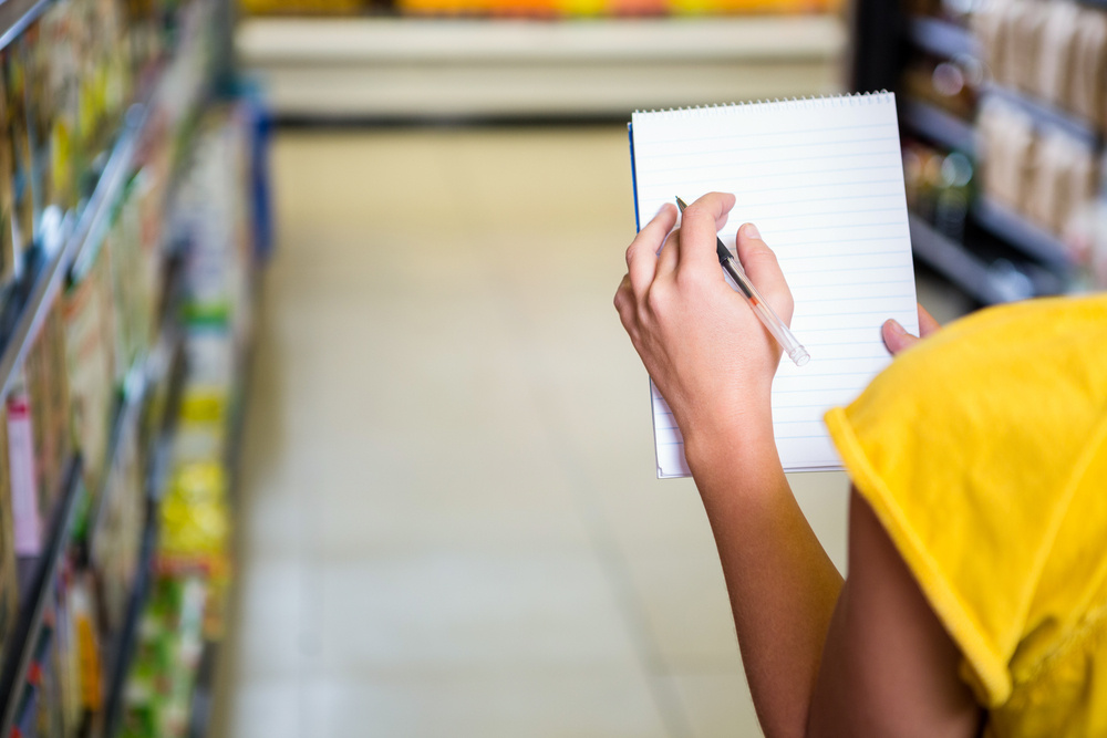 Woman checking list at supermarket